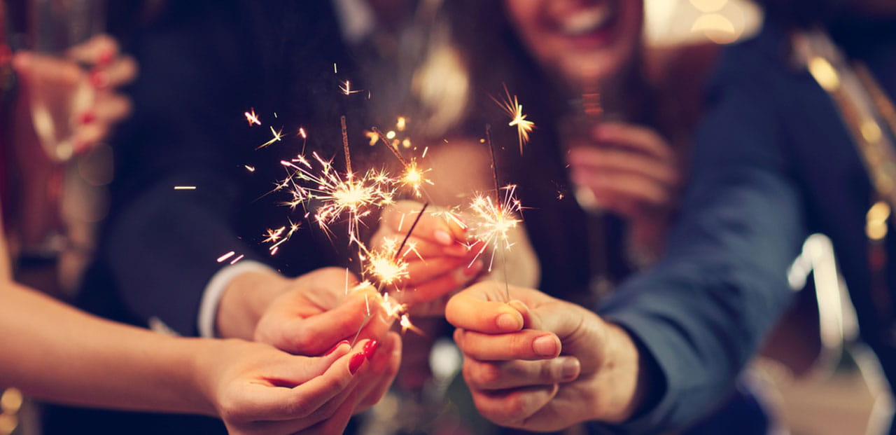Close up of four people holding firecrackers. 